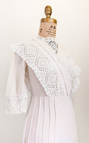 pink lace dress on a mannequin against a plain background