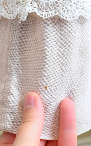 Close-up of a fabric with lace trim and a hand holding it