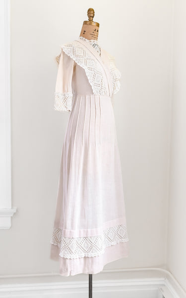 pink lace dress on a mannequin against a white wall