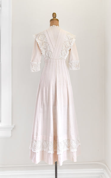 pink lace dress on a mannequin against a white wall