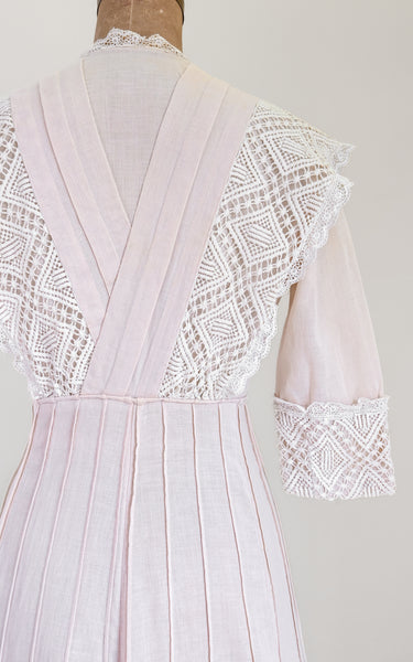 Light pink dress with lace detailing on a plain background
