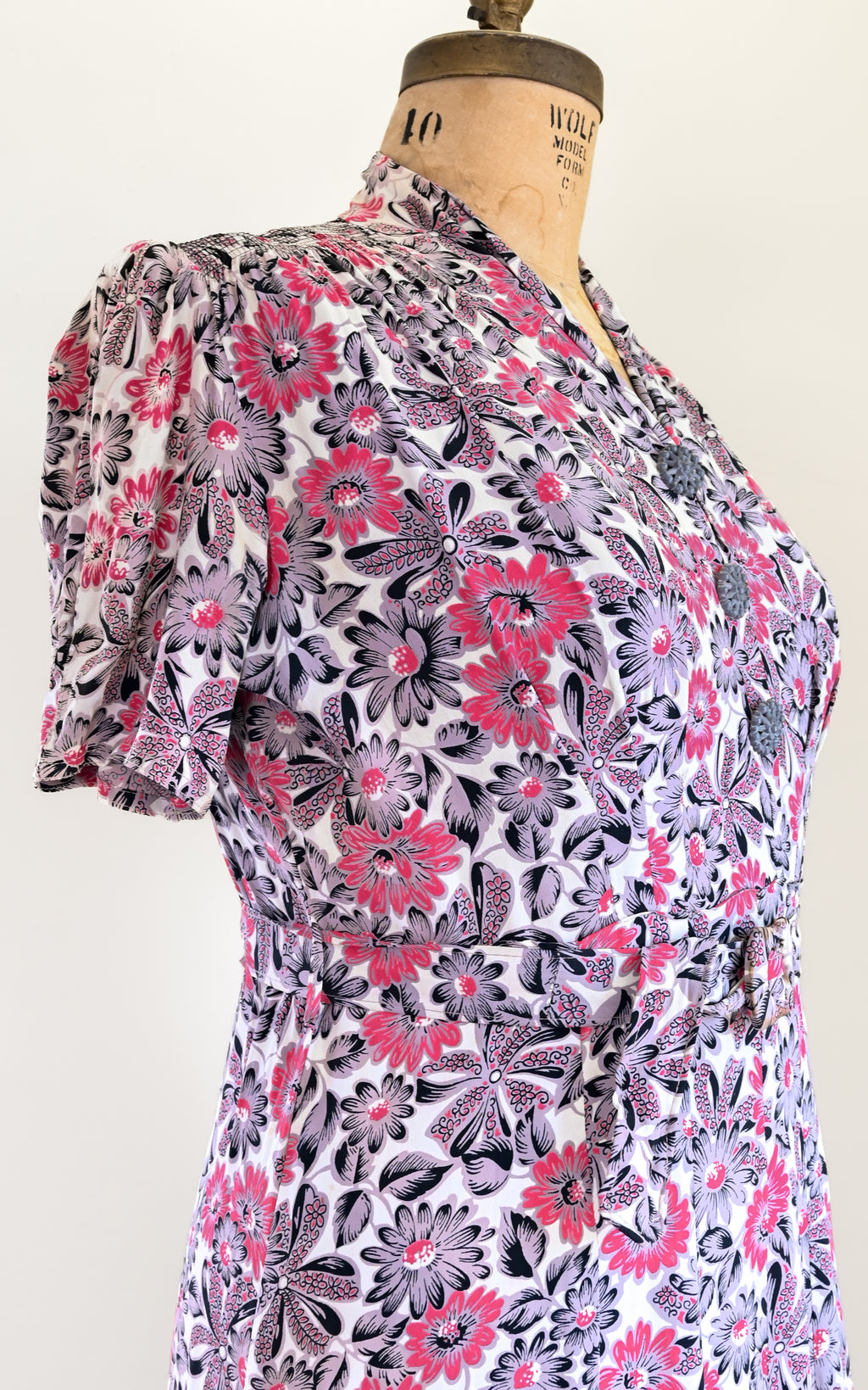 Floral patterned dress on a mannequin against a white background