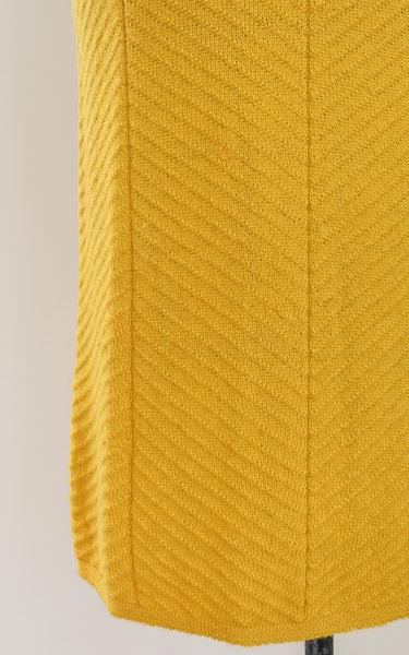 Close-up of a vintage knit textured yellow fabric with a neutral background