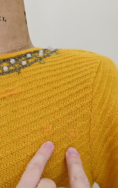 Mends visible on a vintage knit top