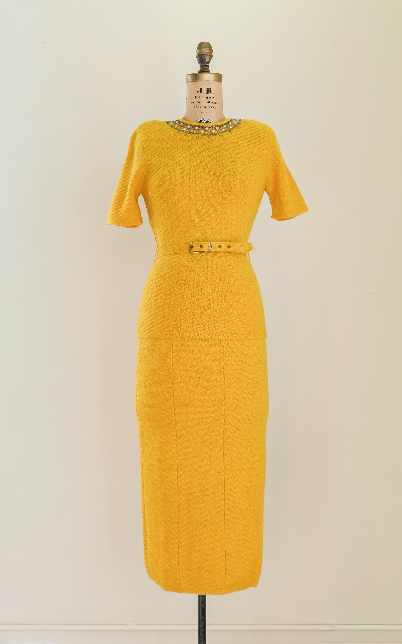 vintage 1930s Yellow knit dress on a mannequin against a plain background