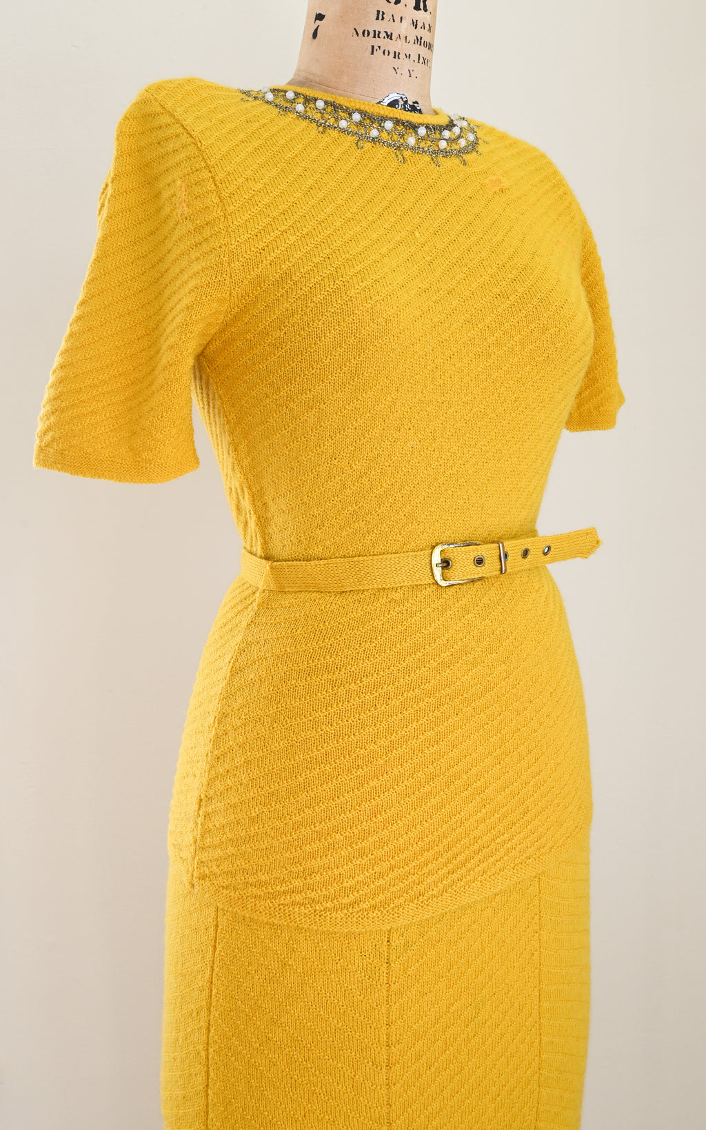 vintage 1930s Yellow knit dress on a mannequin against a plain background